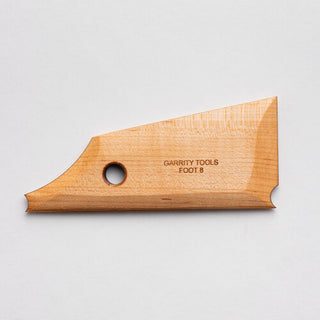 Foot 8 tool with a simple curve and straight edge for creating rounded feet. Flat bottom for stability and shaping while spinning. 5" x 2", made of maple wood. Handmade in St. Louis, MO. Amaranth Stoneware Canada.