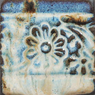 Glossy cream glaze with runny dark specks, breaking on texture with peachy float, great for layering. Amaranth Stoneware Canada.