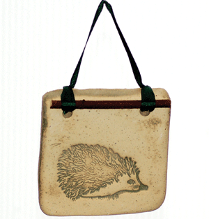 Handcrafted 4x4-inch stoneware Botanicals featuring seasonal plants and creatures. Finished with dogwood and ribbon. Weatherproof. Handcrafted in Kingston, Ontario at Amaranth Stoneware.