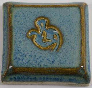 Arctic Blue glaze, a glossy, opaque light blue on white clay, and green-blue on red clay, breaks brown over texture. Amaranth Stoneware Canada. 