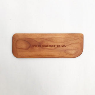 Fishstick Tool with four corner profiles and flat sides for compressing and pulling clay. Keeps projects clean, centered, and smooth. 5" x 1.75", made of cherry wood. Handmade in St. Louis, MO. Amaranth Stoneware Canada.